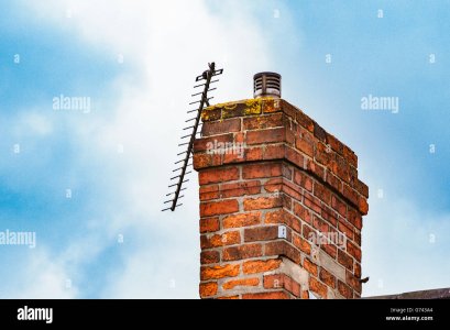 broken-tv-aerial-on-a-brick-chimney-against-a-blue-sky-G743A4.jpg